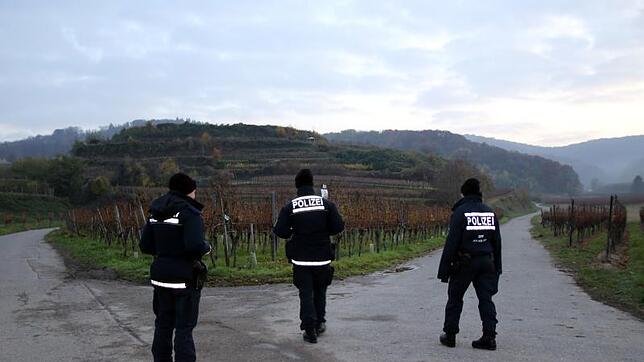 Polizisten sichern die Zufahrtsstraßen zum Bestattungswald Kaiserstuhl (im Hintergrund). Dort in der Nähe wurde die getötete Joggerin ...