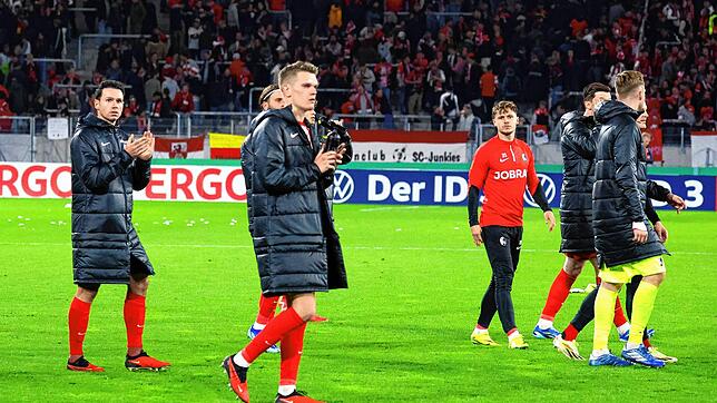 Die vom Pokal-Aus enttäuschten Freiburger Profis auf dem Weg in die Fankurve.