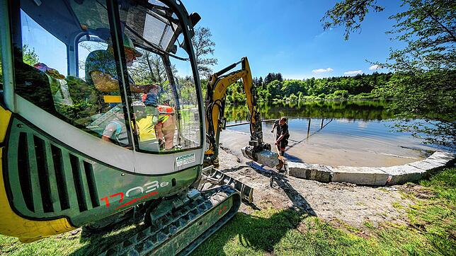 Mitarbeiter der städtischen Betriebe befestigen den Badebereich am Buchenseebad. Denn es sieht gut aus, dass auch für jetzt beginnende ...