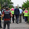 OB Simon Gröger (Bildmitte) und Schulleiter Markus Zähringer (5.v.r.) gehen mit Einsatzkräften der Polizei in das Gebäude. Bild: Gerald ...