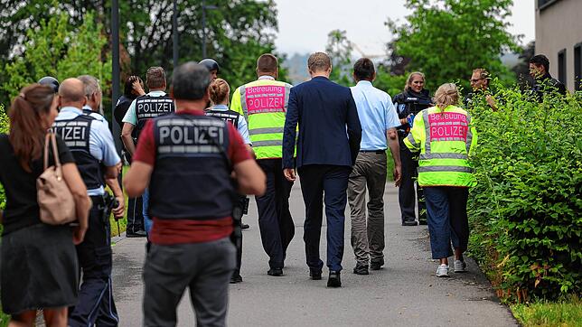 OB Simon Gröger (Bildmitte) und Schulleiter Markus Zähringer (5.v.r.) gehen mit Einsatzkräften der Polizei in das Gebäude. Bild: Gerald ...