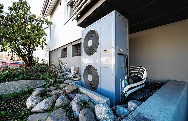 Eine moderne Wärmepumpe vor einem Haus. Für die Grundsteuer ist die Art der Bebauung nicht relevant.
