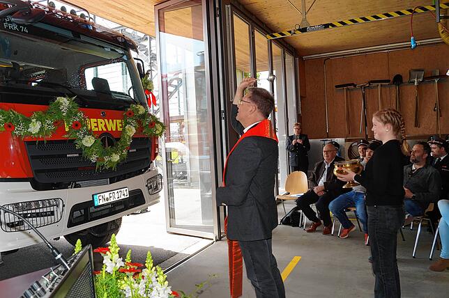 Dekan Peter Nikola segnete den neuen Gerätewagen, Jugendfeuerwehrmitglied Victoria Vogel assistierte ihm dabei.