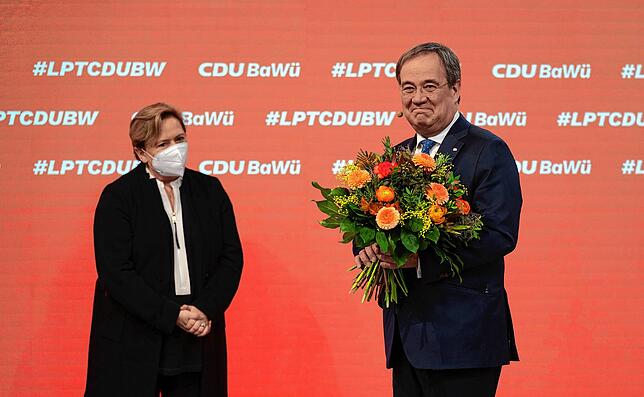 Armin Laschet (r), CDU-Bundesvorsitzender, hält beim Online-Parteitag der CDU Baden-Württemberg ein Blumenstrauß in den Händen, der ihm ...