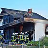 Feuerwehrleute stehen vor der Brandstelle.