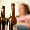 Eine junge Frau sitzt hinter leeren Bierflaschen. Über die Rolle von Suchtmitteln wie Alkohol während der Corona-Pandemie informierte ...