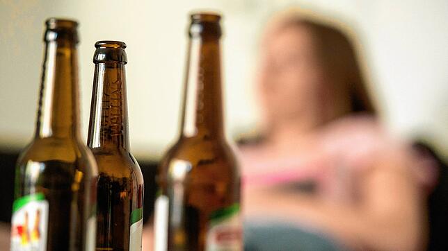 Eine junge Frau sitzt hinter leeren Bierflaschen. Über die Rolle von Suchtmitteln wie Alkohol während der Corona-Pandemie informierte ...