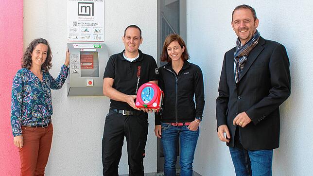 Zeigen den neuen Laien-Defibrillator im Durchgang zum Parkplatz am Dorfgemeinschaftshaus Orsingen (von links): Johanna Ziegler (Björn ...