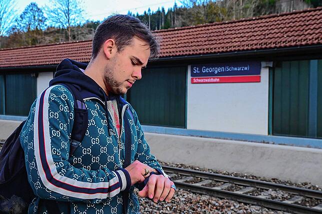 Kommt der Zug pünktlich? Alexej Zhakarine schaut auf Uhr am Gleis am Bahnhof in St. Georgen. Genau im Abiturzeitraum wird die ...