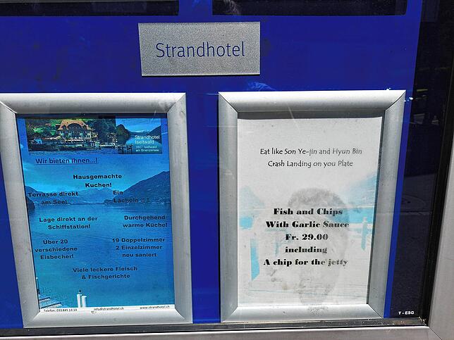 „Iss wie Son Ye-jin und Hyun Bin – Crash Landing on you Platte“ bewirbt das Strandhotel ein Gericht am Dorfplatz.
