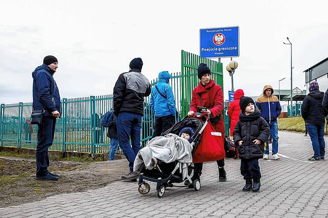 Eine ukrainische Familie geht durch den Grenzübergang nach Polen. Aus der Ukraine sind innerhalb von 48 Stunden nach Kriegsausbruch mehr ...