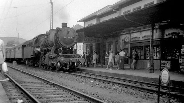 Eine Dampflok steht in den 70er Jahren auf Gleis 1 mit dem Kiosk.