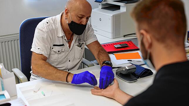 Ein ebm-papst-Mitarbeiter bei einem Corona-Schnelltest in einem Sanitärszimmer. Dem Unternehmen liegt direkt ein Ergebnis vor.