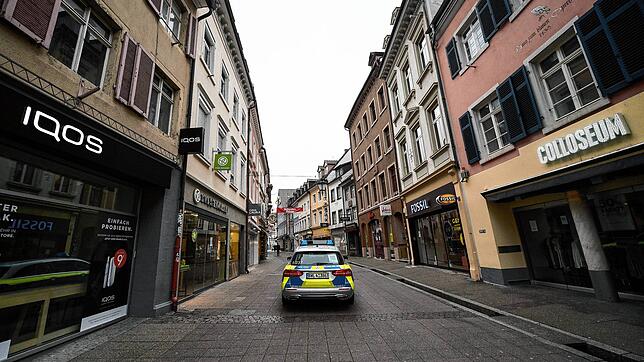 Ein Polizeifahrzeug fährt durch eine Gasse in der Innenstadt.