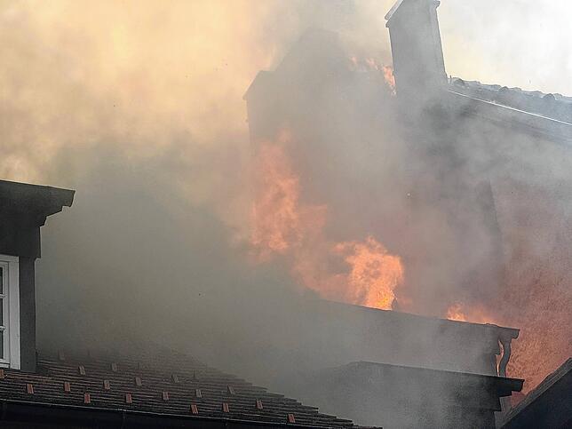 Die Flammen lodern an der Wand des benachbarten Hauses hoch.