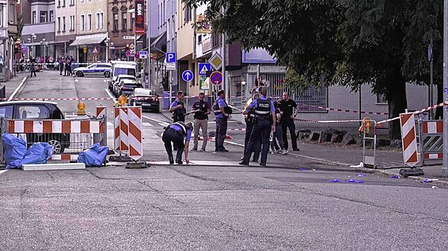 Polizeibeamte untersuchen das Umfeld eines Tatorts. Nach einem Raubüberfall auf eine Tankstelle im saarländischen Völklingen ist ein ...