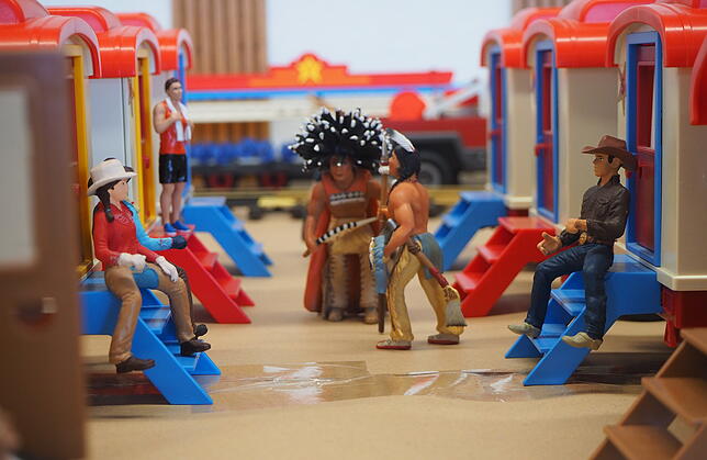 Zwischen den Artistenwagen bereitet sich die Wildwest-Gruppe auf ihren Auftritt vor.