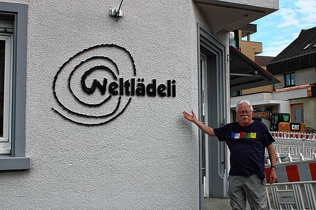 Willi Moosmann vor dem Weltlädeli. Das Logo hat er selbst entworfen.
