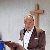 Stadtrat Günter Hornstein, wie Rudolf Beck ehemaliger Ortsvorsteher von Nußdorf, liest dessen Grußworte. Im Hintergrund das Holzkreuz ...