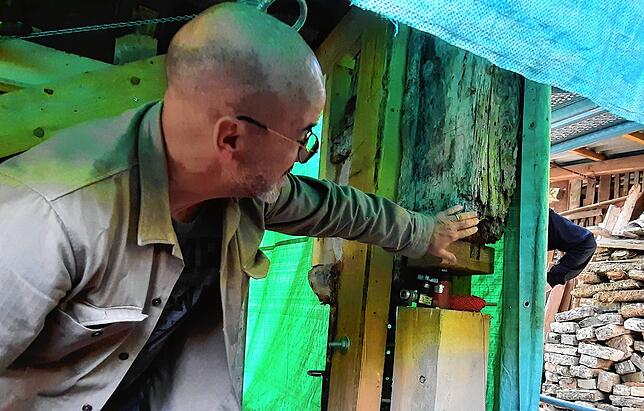 Bauherr Mathias Kreibich zeigt den tragenden Balken am Hauseck, der teils erhalten werden kann, teils ersetzt werden muss.