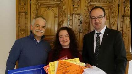 Die Weihnachtsmarkthändler Michael Breuninger und Karin Simmoleit übergeben einen großen Stapel Unterschriften an OB Uli Burchardt. ...