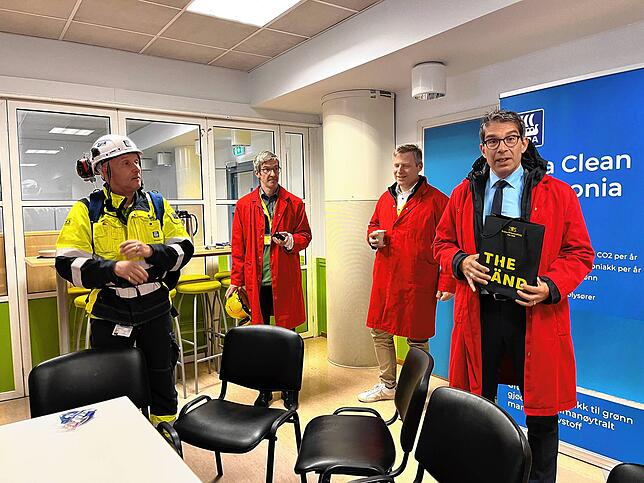 Baden-Württembergs Umwelt-Staatssekretär Andre Baumann (rechts) übergibt einem Verantwortlichen im norwegischen Horoya-Industriepark ...