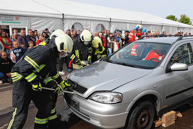 Mit Spreizer und Schere versuchen die Feuerwehrleute das Fahrzeuginnere freizulegen, während das DRK eine Erstversorgung der Verletzten ...