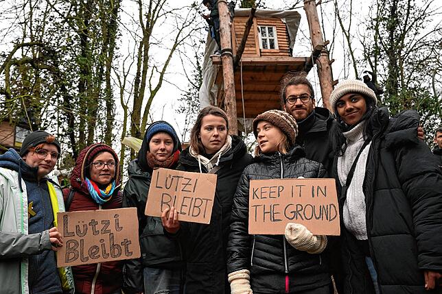 Luisa Neubauer (mit „Lützi bleibt“-Schild) und Greta Thunberg (rechts daneben) beim Protest in Lützerath.