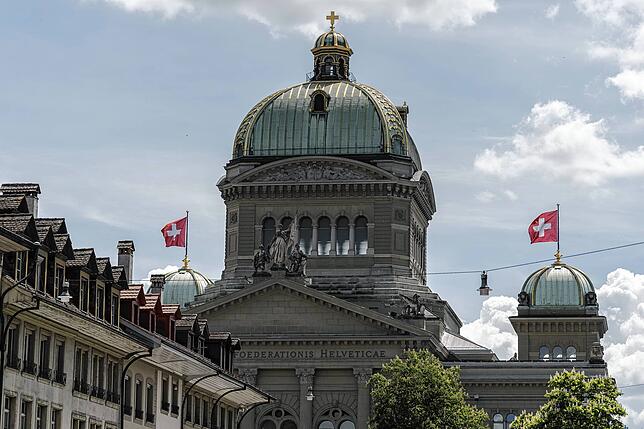 Die Schweizer Nationalfahne weht auf den kleinen Kuppeln auf dem Bundeshaus.