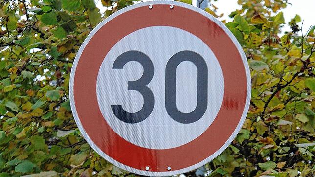 Ein Schild in einer Ortsdurchfahrt schreibt aus Lärmschutzgründen Tempo 30 vor.