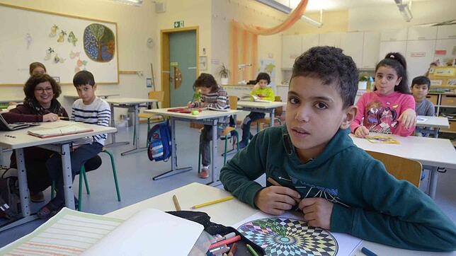 Mohamed, zehn Jahre alt, ist gerade mit seiner Stillarbeit befasst. Lehrerin Christina Schenk (links) kümmert sich um Subhanullah. ...