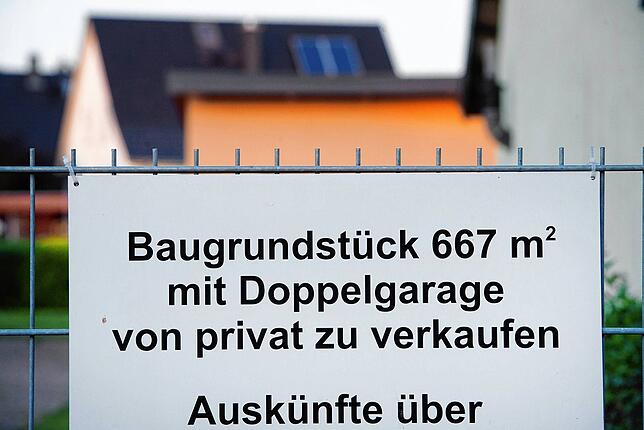 Blick auf ein Verkaufsschild mit dem Schriftzug &bdquo;Baugrundstück&ldquo;. Für Besitzer von Einfamilienhäusern könnte es teurer werden.
