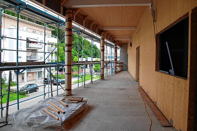 Im zweiten Stockwerk befindet sich die Kita, die als Holzbau auf den Betonklotz gebaut wird. Ihr Eingang und die markante Gläserfront ...