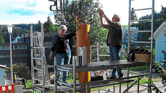 Hildegard Obert und Margot Allgaier von der Aktionsgruppe Aktiv für Schönwald streichen in luftiger Höhe die Skulptur am Kindergarten ...