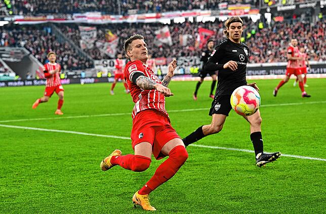 Freiburgs Lukas Kübler (l) und Stuttgarts Borna Sosa kämpfen um den Ball.