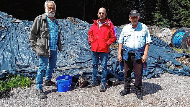 Die Umweltaktivisten Dieter Berger, Thorsten Werle und Bernd Marterer (von links) im Juli 2023 vor einem mit Planen abgedeckten Haufen ...