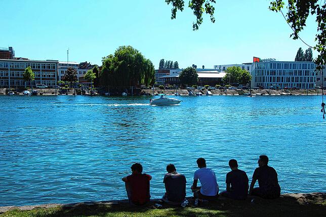 Am Seerhein beobachten diese jungen Männer das Geschehen auf dem Wasser.