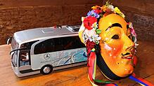 Eine Eschinger Hanselmaske lehnt am Modell eines Reisebusses. Diese Kombination thematisiert das Ungemach, das vielen Narren in der ...