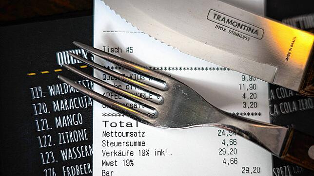 Eine Rechnung der Mehrwertsteuer liegt auf der Speisekarte eines Restaurants.