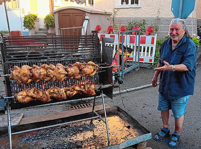 Herbert Volk zeigt an seinem Grillstand die beliebten Grillhähnchen.
