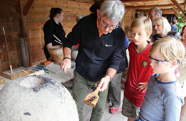 Hier zeigt Archäologe Peter Walter im Jahr 2017 jungen Besuchern, wie man früher Glasperlen gemacht hat.