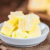 Old wooden table with a portion of Butter (selective focus; close-up shot))