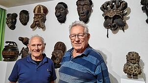 Masken erinnern in Dieter Gruns (rechts) Wohnzimmer an seine Afrikareisen. Bruno Dürrholder unterstützt bei der Abwicklung der ...