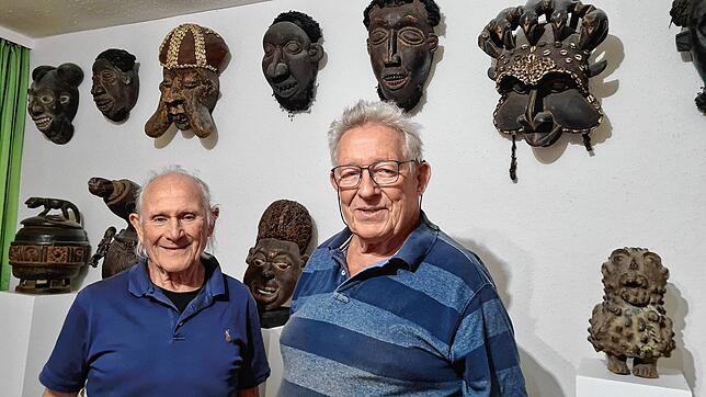 Masken erinnern in Dieter Gruns (rechts) Wohnzimmer an seine Afrikareisen. Bruno Dürrholder unterstützt bei der Abwicklung der ...