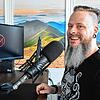 Andy Feind vor seinem Mikrofon. Hier vertont der professionelle Sprecher Podcasts.