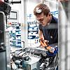 Die Leistungselektronik ist die Steuerzentrale eines E-Antriebs: Ein ZF-Mitarbeiter montiert sie an das Antriebssystem.