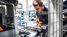 Die Leistungselektronik ist die Steuerzentrale eines E-Antriebs: Ein ZF-Mitarbeiter montiert sie an das Antriebssystem.