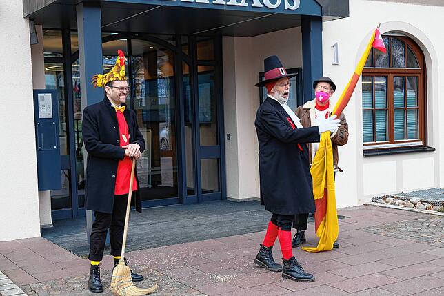 Bürgermeister Johannes Henne übergibt den narren einen Besen, um Corona auszufegen.