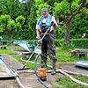 Bernhard Kreutter befreit die blauen Bahnen im hinteren Teil der Minigolfanlage nach dem Hochwasser vom Schlamm.