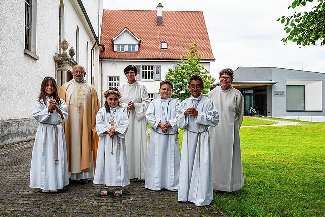 Diese vier Kinder haben in der katholischen Herz-Jesu Kirche ihre erste heilige Kommunion empfangen, hinten von links Kooperator Pfarrer ...